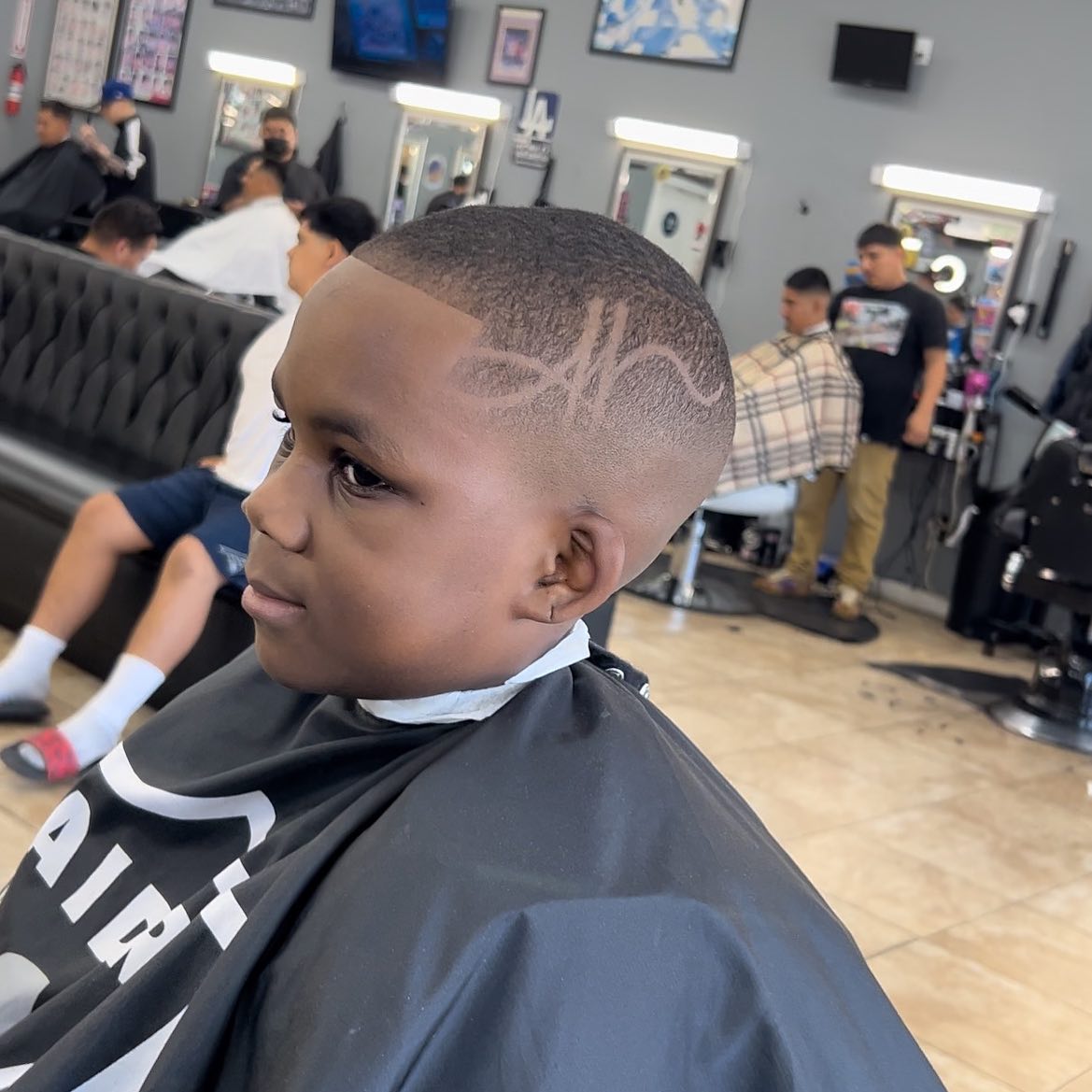A young client getting a haircut at the shop, 2023